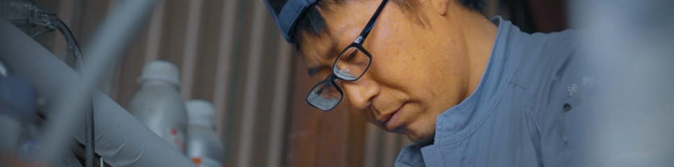 牛舎で作業中の池野雅人さん